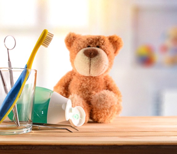 Teddy bear on a table with oral hygiene products