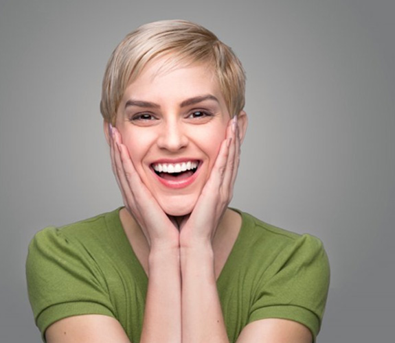 Woman holding her face and showing off straighter smile 