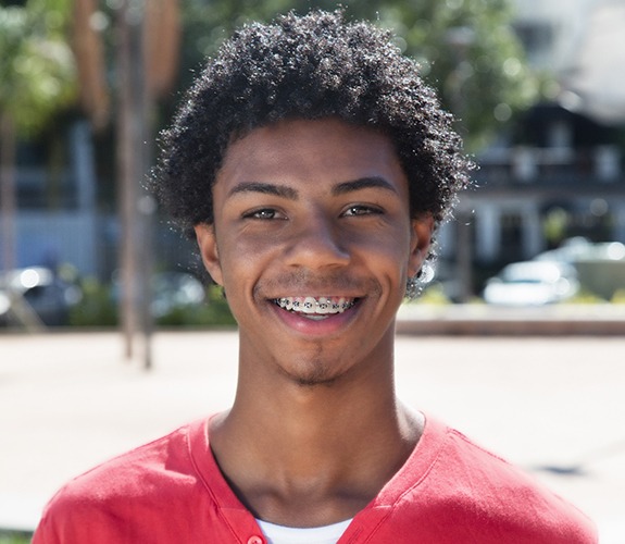 Young man with red shirt smiling with braces in Sycamore, IL