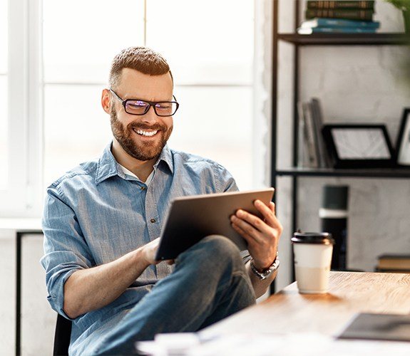 Man sitting at a desk with a tablet