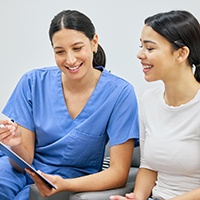 Dental staff member discussing payment with female patient