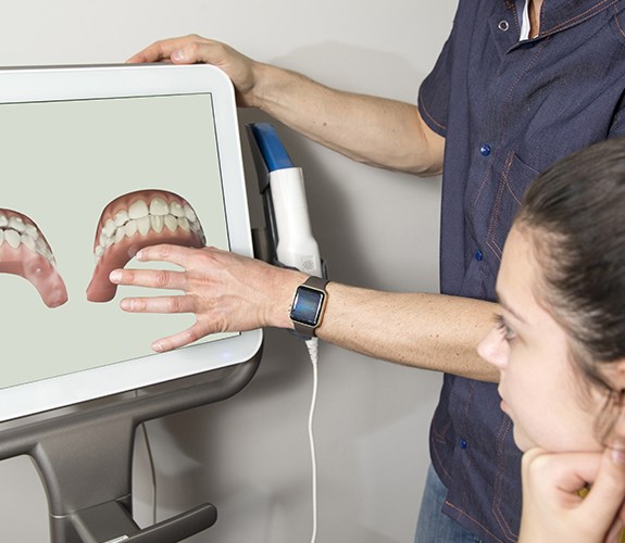 Dentist and patient looking at Invisalign treatment guide