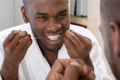 Man flossing teeth in Sycamore 