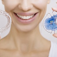 Closeup of patient holding retainers for after orthodontics in Sycamore, IL