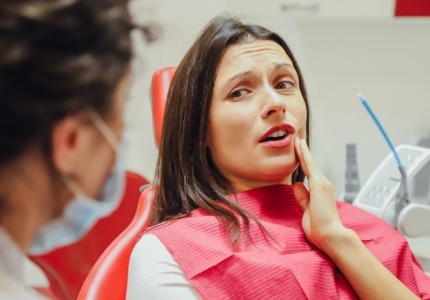 Woman in need of gum disease treatment holding jaw in pain