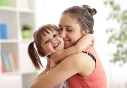 Mother holding daughter after children's dentistry visit