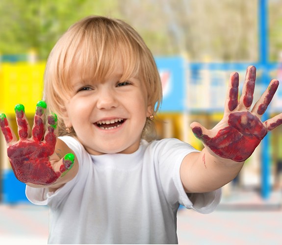 Boy smiling with painted hands in Sycamore