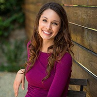 Young woman in purple smiling with veneers