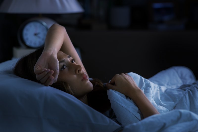 woman appearing anxious while in bed