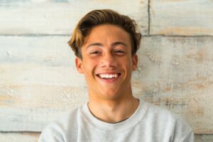 Male teenager wearing a sweater and smiling